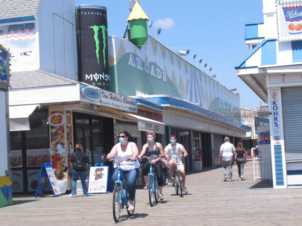 Bicyclists ride on the boardwalk in Seaside Heights, N.J. on May 15, 2020, the on the first day it opened during the coronavirus outbreak. It and another popular Jersey Shore beach, Point Pleasant Beach, were among those allowing people back onto the sand with some restrictions to try to slow the spread of the virus. (AP Photo/Wayne Parry)