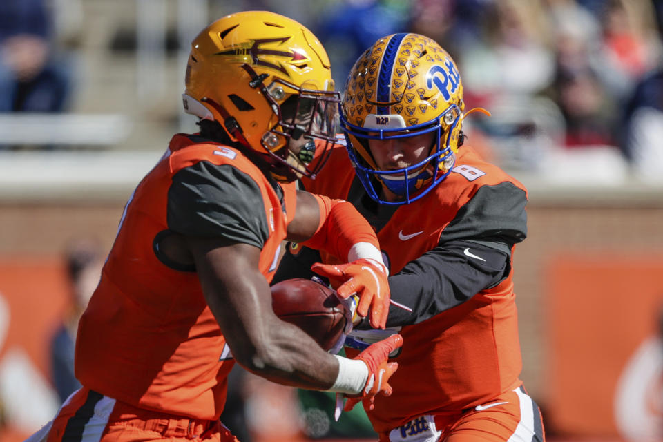 National Team quarterback Kenny Pickett, of Pittsburgh (8), hands the ball off to running back Rachaad White, of Arizona State (3), during the first half of an NCAA Senior Bowl college football game, Saturday, Feb. 5, 2022, in Mobile, Ala. (AP Photo/Butch Dill)