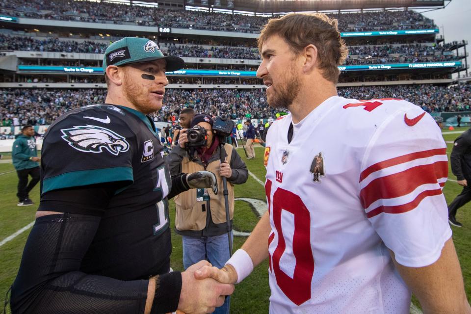 Philadelphia Eagles quarterback Carson Wentz talks with New York Giants quarterback Eli Manning after the game, Sunday, Nov. 25, 2018, in Philadelphia. The Eagles won 25-22. (AP Photo/Chris Szagola)