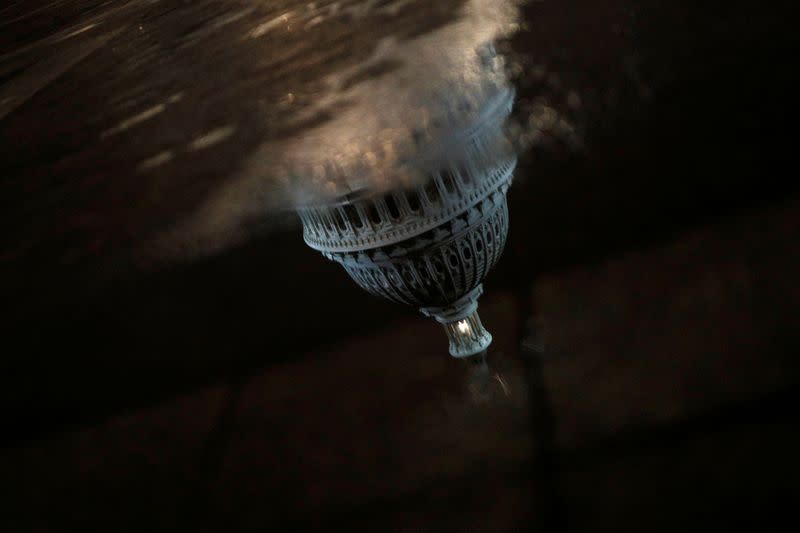 A reflection of the U.S. Capitol Building as seen ahead of a vote on the coronavirus (COVID-19) relief bill on Capitol Hill in Washington