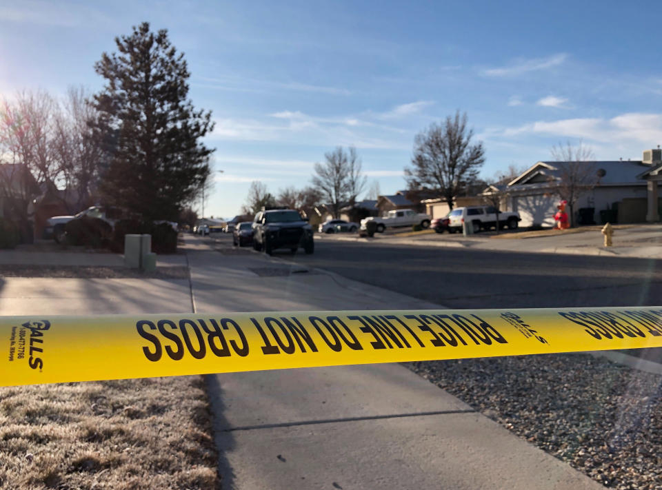 Police have a residential street cordoned off as detectives investigate the deaths of four people found Christmas Day inside a home in Rio Rancho, N.M., on Thursday, Dec. 26, 2019. All of the victims appeared to have suffered gunshot wounds, police said in a statement posted on Facebook. Police did not identify the victims or say whether a suspect or suspects have been identified. (AP Photo/Susan Montoya Bryan)
