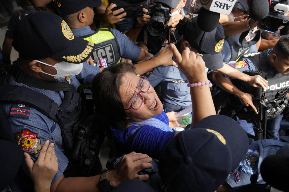 Detained former opposition Senator Leila de Lima, center, reacts as she goes out of the Muntinlupa trial court on Friday, May 12, 2023 in Muntinlupa, Philippines. De Lima was acquitted by the Muntinlupa court in one of her drug related charges she says were fabricated by former President Rodrigo Duterte and his officials in an attempt to muzzle her criticism of his deadly crackdown on illegal drugs. (AP Photo/Aaron Favila)