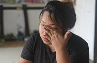 Diana Khumanthem, 30, wipes her tears as she recounts her COVID-19 experience sitting at home in Imphal, in the northeastern Indian state of Manipur, Monday, June 28, 2021. Diana lost both her mother and sister to the virus in May. Treatment costs wiped out the family's savings, and when the private hospital where she died wouldn’t release her sister’s body for last rites until a bill of about $5,000 was paid, she pawned the family's gold jewelry to moneylenders. When that wasn’t enough, friends, relatives and her sister’s colleagues helped. She still owes some $1,000. (AP Photo/Yirmiyan Arthur)