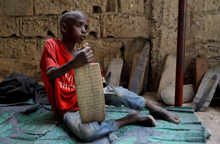 Omar Wone, 8, from Futa, a Koran student, called a talibe, sits on the floor of the daara (Koranic school) where he lives and learns Koran in Saint-Louis, Senegal, February 8, 2019. REUTERS/Zohra Bensemra