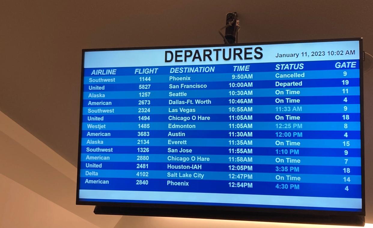 The departure board at Palm Springs International Airport shows a cancelled flight and delays Wednesday morning, hours after an FAA computer glitch that affected thousands of flights nationally.
