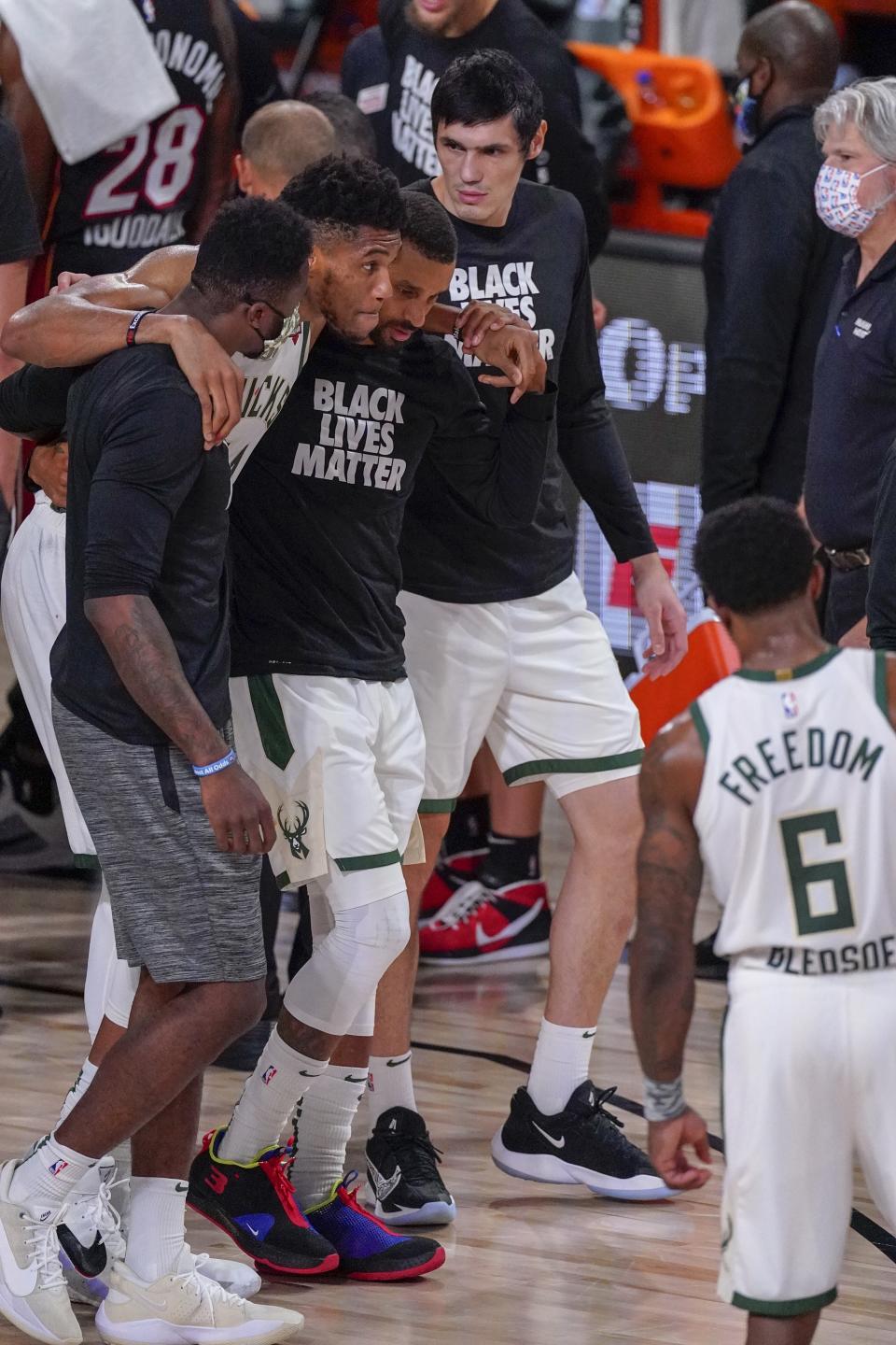 Milwaukee Bucks' Giannis Antetokounmpo is helped off the court after hurting his ankle during the first half of an NBA conference semifinal playoff basketball game against the Miami Heat Sunday, Sept. 6, 2020, in Lake Buena Vista, Fla. (AP Photo/Mark J. Terrill)