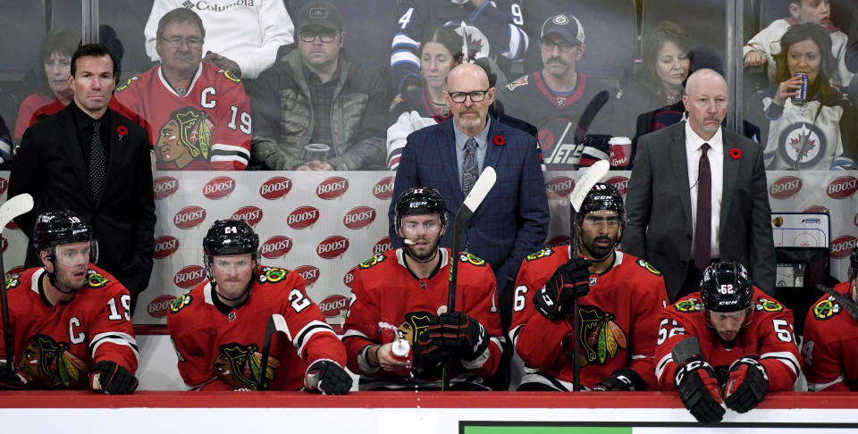 Chicago Blackhawks head coach Luke Richardson, left, and assistant coaches Derek King and Derek Plante watch from the bench against the Winnipeg Jets during the third period of an NHL hockey game in Winnipeg, Manitoba, Saturday, Nov. 5, 2022. (Fred Greenslade/The Canadian Press via AP)