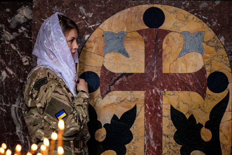 A female Ukrainian soldier prays during an orthodox Easter service (AFP via Getty Images)