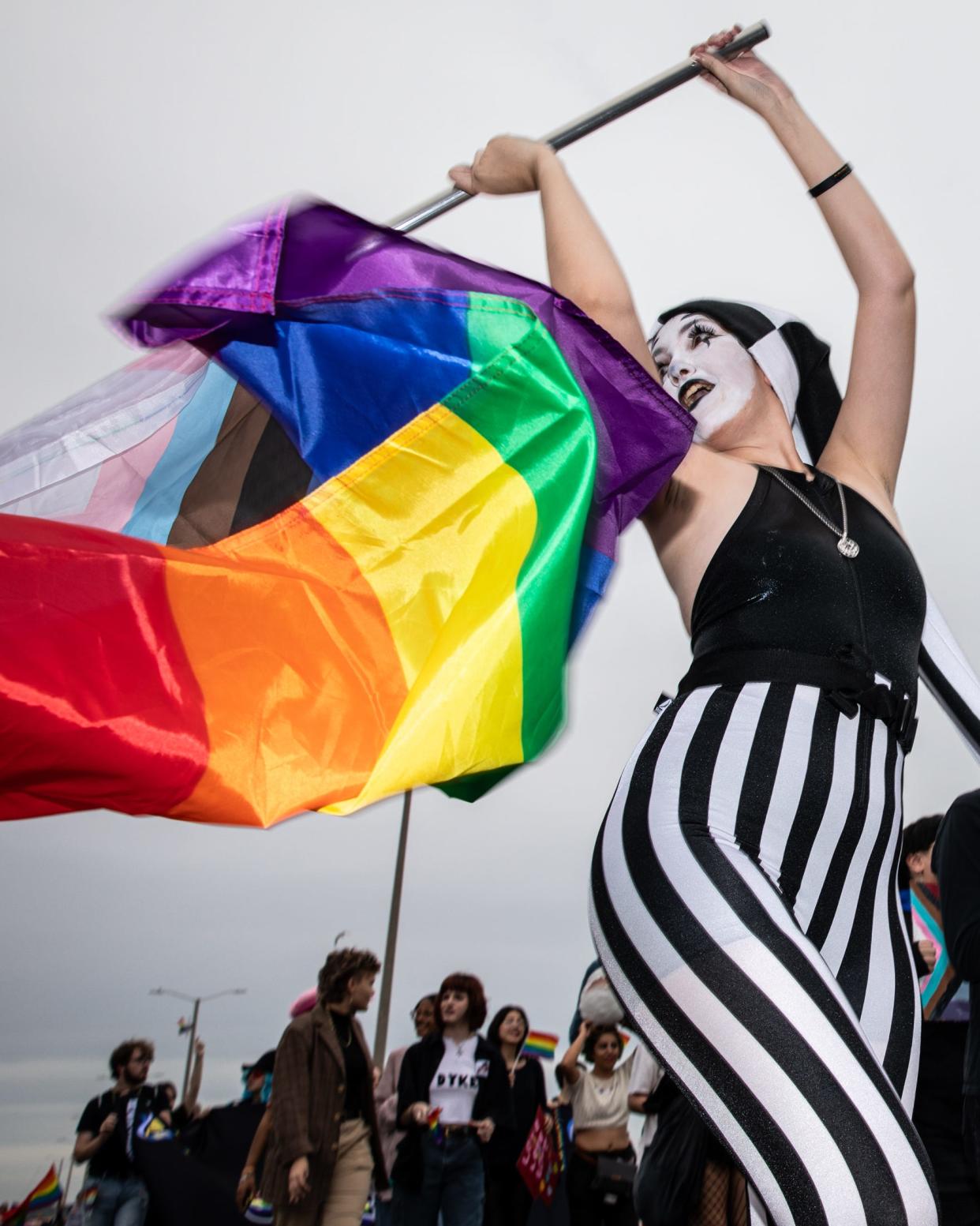 Kara Jefferies waves a Pride flag and marches with the Islander Feminists during the Pride Parade on Saturday, Oct. 7, 2023, in Corpus Christi, Texas.