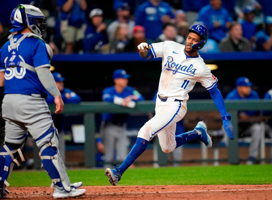 Kansas City Royals third base Maikel Garcia (11) scored a run against Toronto Blue Jays catcher Alejandro Kirk (30) during the fifth inning at Kauffman Stadium on April 23, 2024, in Kansas City, Missouri.