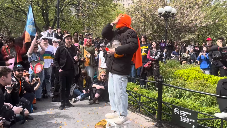 Cheeseballman shoving cheeseballs into his mouth on a white stool