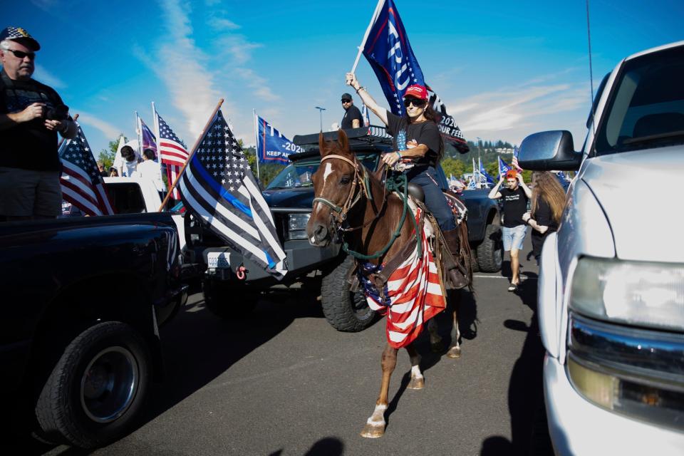 Trump supporters participate in a massive caravan that traveled through Portland (AP)