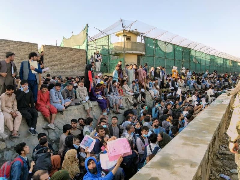 Crowds of people wait outside the airport in Kabul