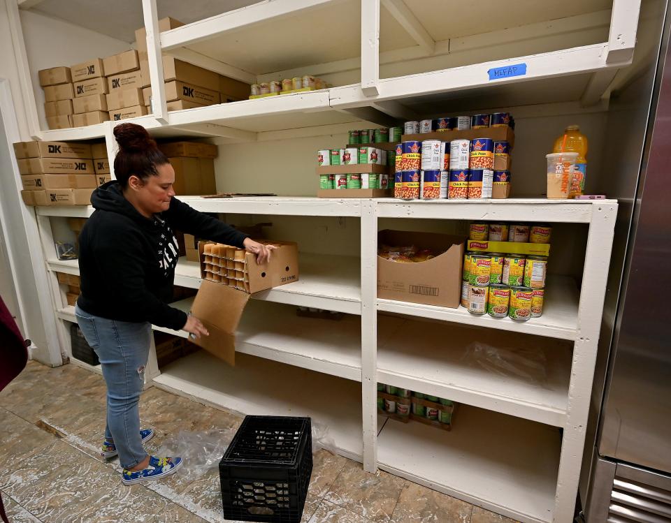 Emergency Assistance Coordinator Yildiz Laza adds more food to emptied-out shelves at Pernet Family Health Service.