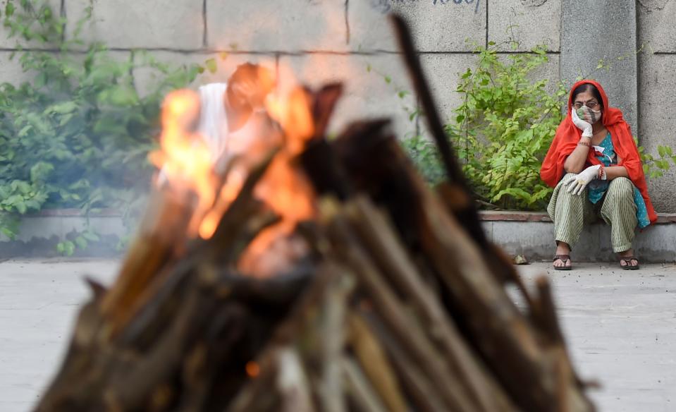 A family member of a COVID victim looks on during cremation at the Seemapuri Cremation Ground, in New Delhi on Friday, 16 April.