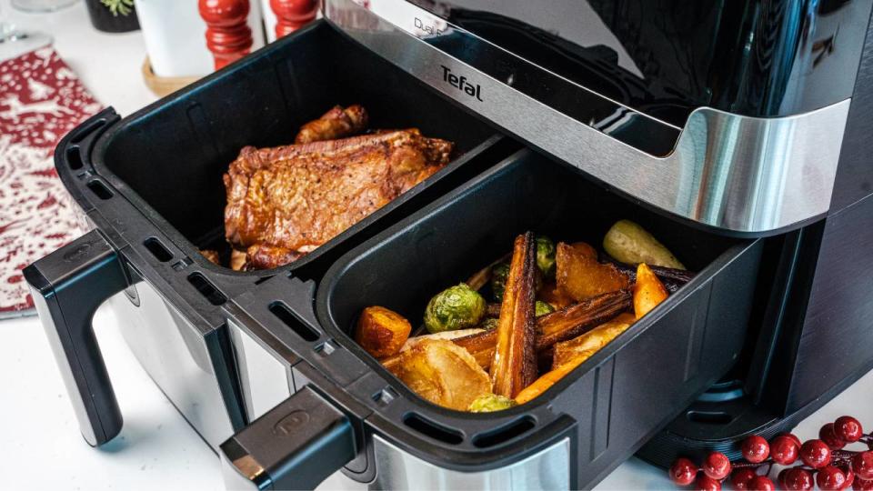 A Tefal air fryer with two baskets filled with Christmas food