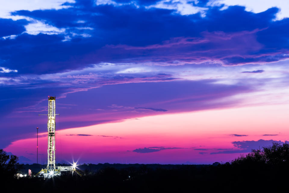 Drilling rig in front of a pink and purple sky