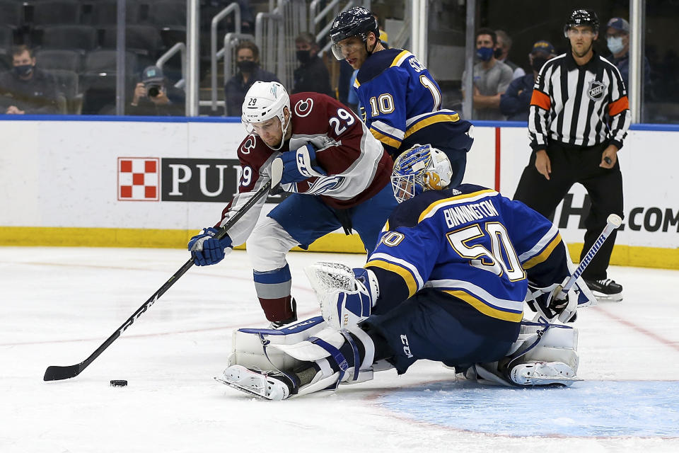 St. Louis Blues goaltender Jordan Binnington (50) defends against Colorado Avalanche's Nathan MacKinnon (29) during the third period in Game 3 of an NHL hockey Stanley Cup first-round playoff series Friday, May 21, 2021, in St. Louis. (AP Photo/Scott Kane)