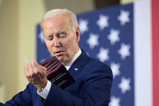 PHOTO: President Biden reads from a pamphlet by Sen. Rick Scott (R-FL), while delivering remarks on his plan to protect and strengthen Social Security and Medicare, as well as lower healthcare costs, at the University of Tampa in Fla., on Feb. 9, 2023. (Mandel Ngan/AFP via Getty Images)