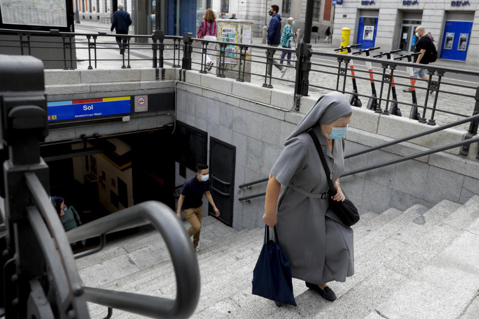 A nun wearing a face mask to prevent the spread of coronavirus climbs stairs of a subway in downtown Madrid, Spain, Friday, Sept. 18, 2020. With more than 11,000 new daily coronavirus cases, the attention in Spain is focusing on its capital, where officials are mulling localized lockdowns and other measures to bring down the curve of contagion. (AP Photo/Manu Fernandez)