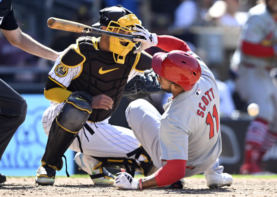 St. Louis Cardinals' Victor Scott II (11) is hit by a pitch as San Diego Padres catcher Kyle Higashioka (20) looks on during the eighth inning of a baseball game, Wednesday, April 3, 2024, in San Diego. (AP Photo/Denis Poroy)