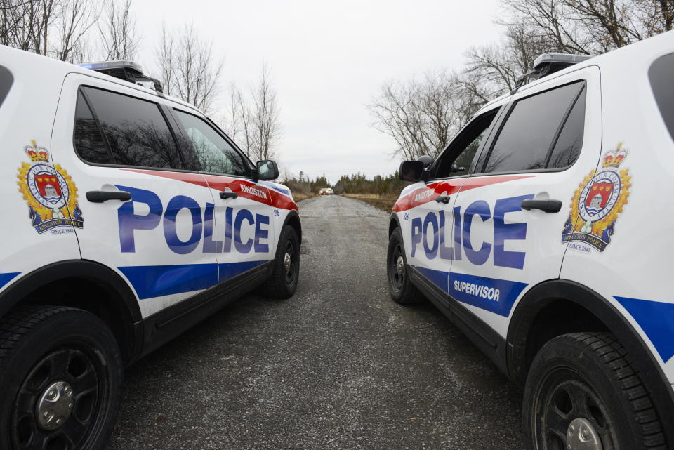 Two Kingston Police cars block a road leading to the site of a fatal plane crash in Kingston, Ontario, on Thursday, Nov. 28, 2019. (Sean Kilpatrick/The Canadian Press via AP)