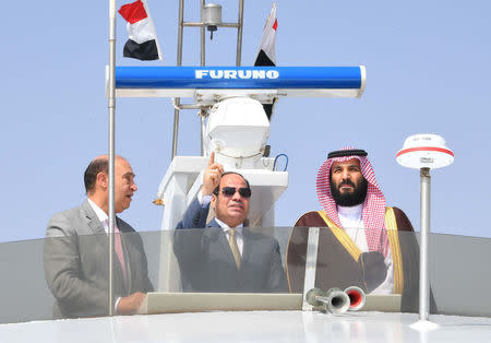 FILE PHOTO: Saudi Crown Prince Mohammad Bin Salman (R) listens to Egyptian President Abdel Fattah al-Sisi (C) during investment projects in the Suez Canal at the city of Ismailia, Egypt, March 5, 2018, in this handout picture courtesy of the Egyptian Presidency. The Egyptian Presidency/Handout