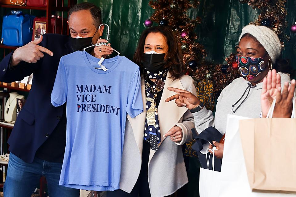 Doug Emhoff holds a t-shirt that says "Madam Vice President" as Kamala Harris looks on