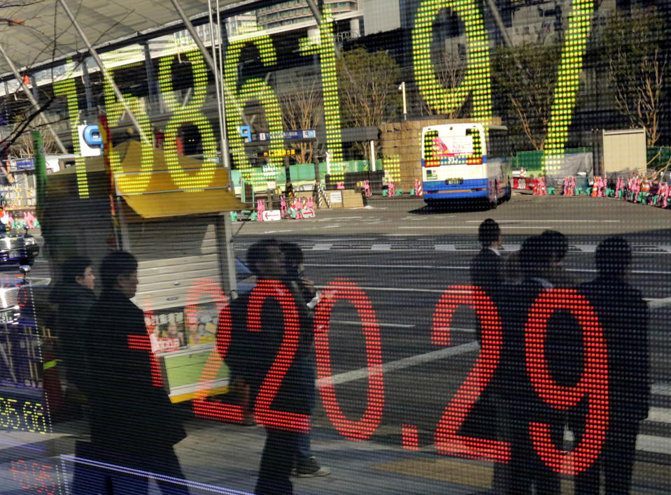People wait for a traffic signal to change in front of an electronic stock indicator in Tokyo, Tuesday, Jan. 21, 2014. Asian stocks rose Tuesday after China's central bank injected extra credit into its financial system, helping to offset concern about slower Chinese growth. China's benchmark Shanghai Composite Index rose just over 1 percent to 2,011.33 points and Tokyo's Nikkei 225 jumped 1.4 percent to 15,866.54. (AP Photo/Shizuo Kambayashi)