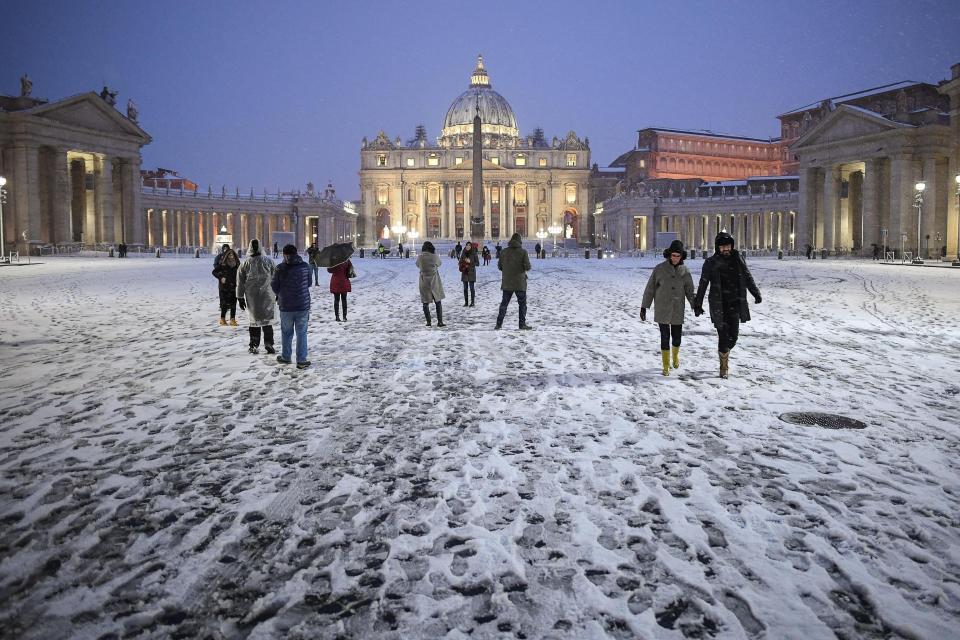 ROM03. EL VATICANO, 26/02/2018.- Turistas y locales pasean por la Plaza de San Pedro que amaneció cubierta de blanco tras una intensa nevada, en el Vaticano, hoy, 26 de febrero de 2018. La ola de frío siberiano, que han llamado Burian, llegó ayer a Italia provocando copiosas nevadas en el norte y un frío intenso que ha llegado hasta los 20 grados bajo cero en algunas localidades y hoy alcanzó el centro del país y Roma, donde los colegios permanecen cerrados. EFE/ ALESSANDRO DI MEO