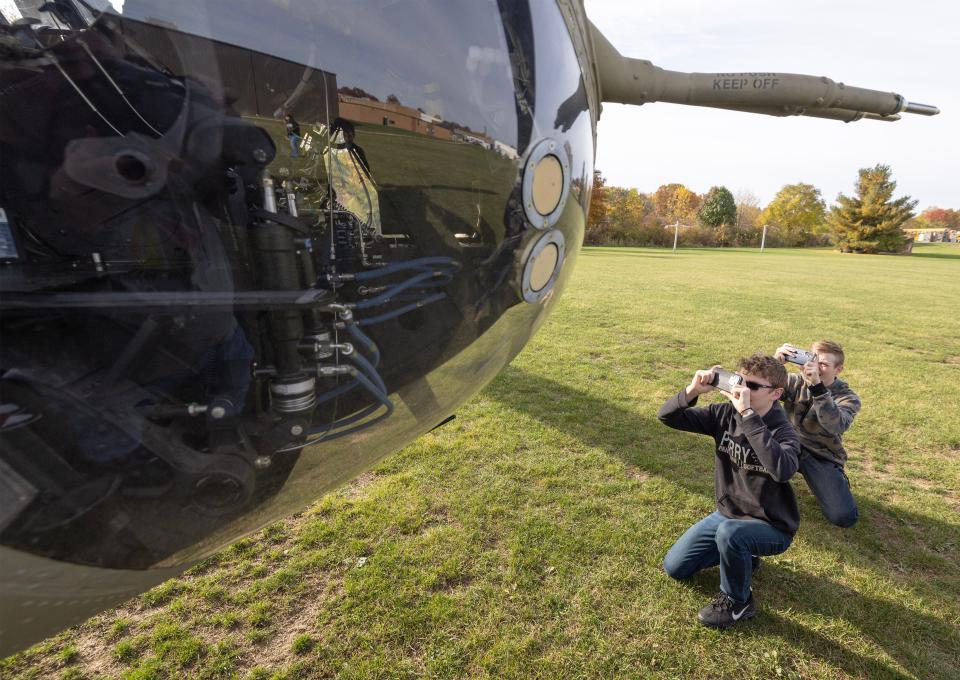Perry juniors Dominic Alessandrini, left, and Andrew Schwing, take picture of a Chinook helicopter that visited Perry High School on Thursday. Perry and McKinley JROTC students were able to get a 15-minute ride on the military aircraft.