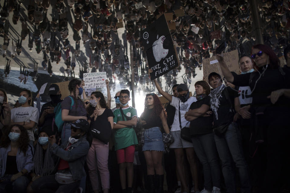 A protester holds a sign that reads "kill, it is being filmed" in Marseille, southern France, Saturday, June 6, 2020, to protest against the death of George Floyd, who died after he was restrained by police officers May 25 in Minneapolis, that has led to global protests. (AP Photo/Daniel Cole)