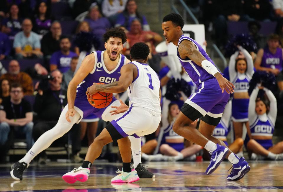 GCU foward Gabe McGlothan (30) and guard Ray Harrison (0) defend ACU guard Damien Daniels (1) during a Feb. 17, 2023, game at GCU in Phoenix.