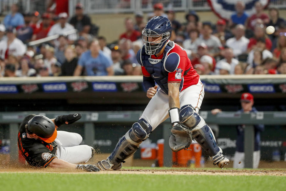 Baltimore Orioles' Ryan McKenna scores as the ball gets past Minnesota Twins catcher Gary Sanchez on a ball by Jorge Mateo and an error by Twins' Jorge Polanco during the eighth inning of a baseball game Friday, July 1, 2022, in Minneapolis. The Twins won 3-2. (AP Photo/Bruce Kluckhohn)