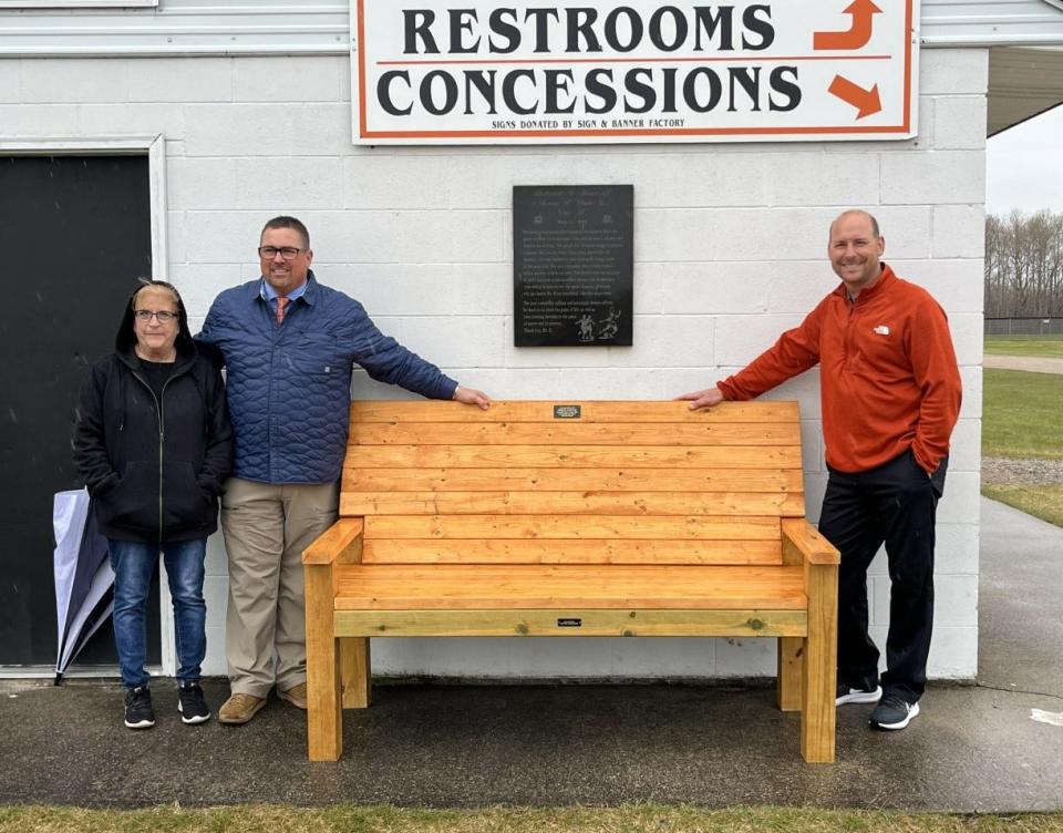 On Friday, Cheboygan Area High School athletics unveiled a new bench in memory of former soccer coach Gregg Spence, who passed away in March. In this photo (from left) are Spence&#39;s wife, Debra, Cheboygan varsity girls soccer coach Tom Markham, and Cheboygan athletic director Jason Friday.