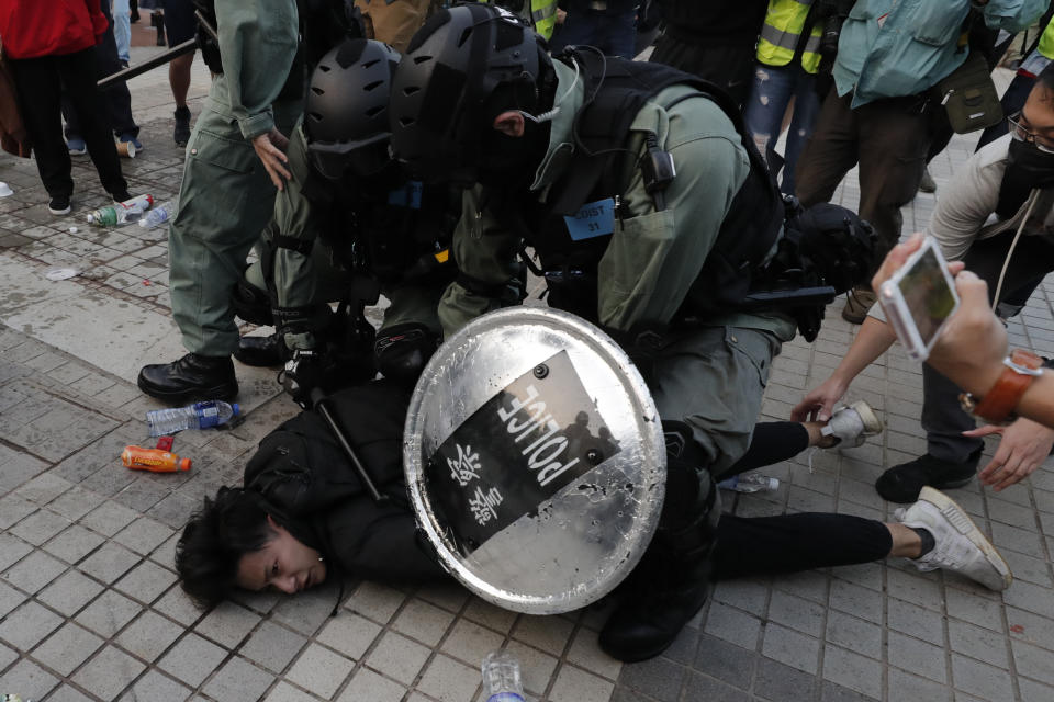 Riot policemen arrest a protester during a rally to show support for Uighurs and their fight for human rights in Hong Kong, Sunday, Dec. 22, 2019. (AP Photo/Lee Jin-man)