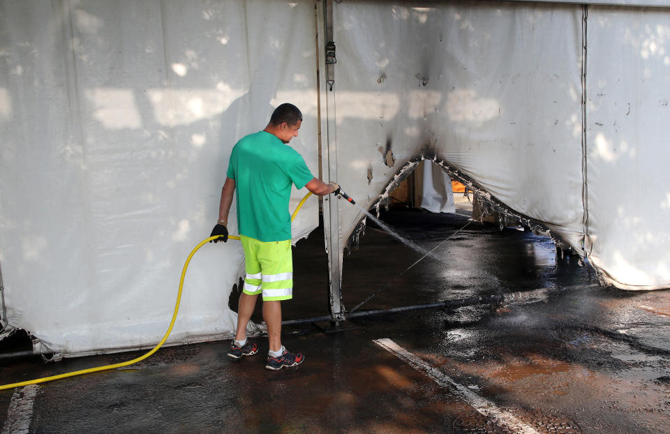 A municipality workers cleans the debris of a Covid-19 vaccination center in Urrugne, southwestern France, Monday, July 19, 2021, following an arson attack on Saturday evening. Two Covid-19 vaccination centers were ransacked in less than 48 hours in France, over the weekend. (AP Photo/Bob Edme)