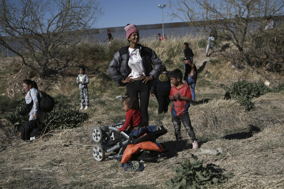 A migrant woman and children wait along the Mexico-U.S. border in Ciudad Juarez, Mexico, Wednesday, March 29, 2023, a day after dozens of migrants died in a fire at a migrant detention center in Ciudad Juarez. (AP Photo/Christian Chavez)