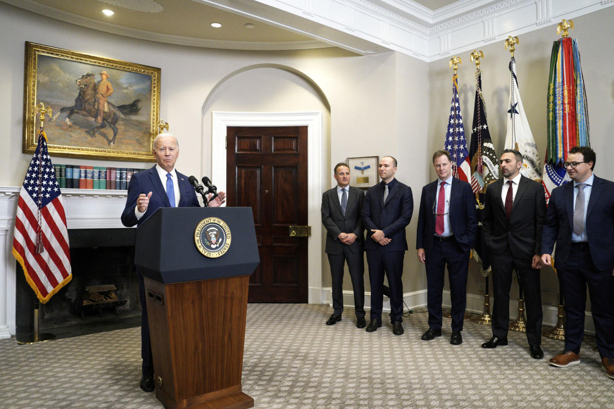 President Joe Biden speaks at a podium while several men in suits look on. (Yuri Gripas / Bloomberg via Getty Images)
