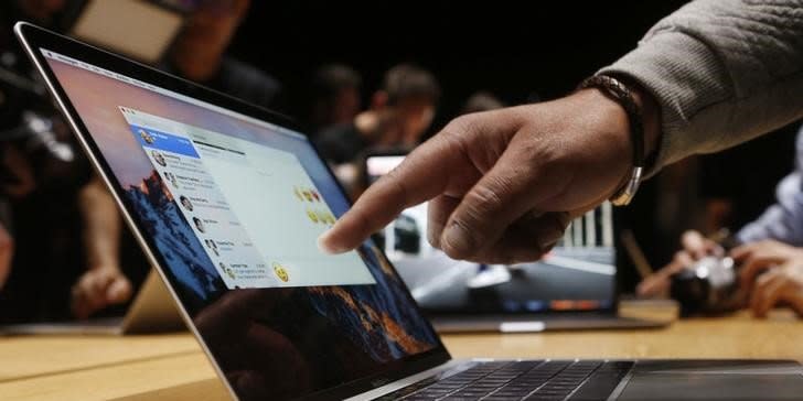 FILE PHOTO - A guest points to a new MacBook Pro during an Apple media event in Cupertino, California, U.S. October 27, 2016.   REUTERS/Beck Diefenbach