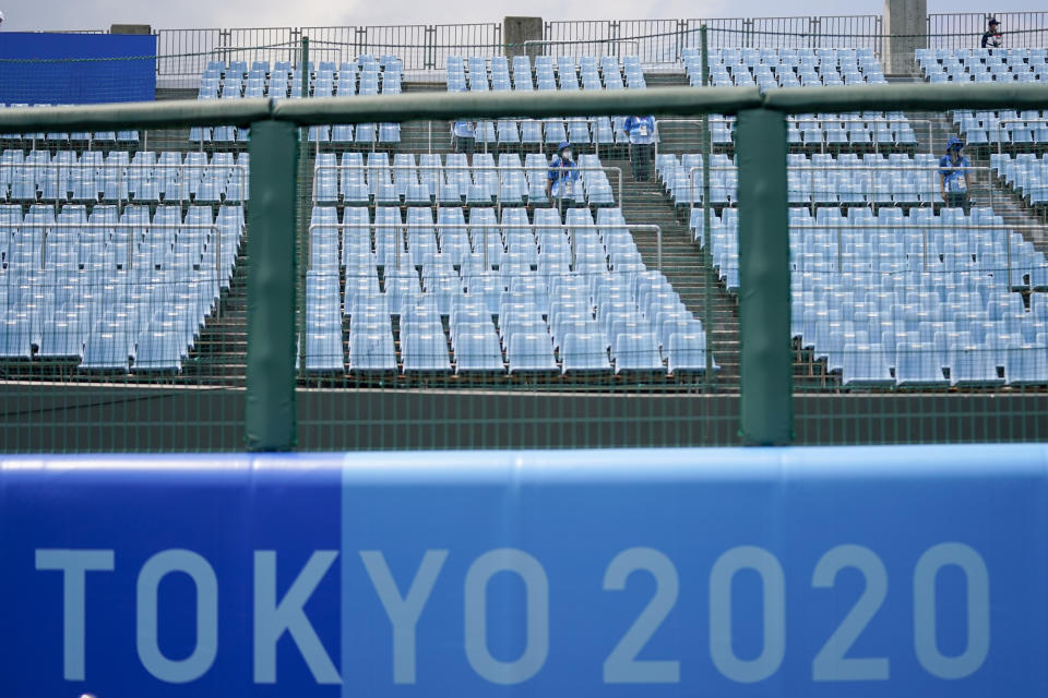 Games staff sit in the empty stands during the softball game between the Mexico and Japan at the 2020 Summer Olympics, Thursday, July 22, 2021, in Fukushima , Japan. (AP Photo/Jae C. Hong)