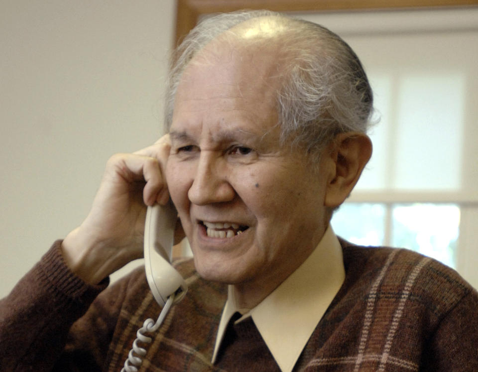 FILE - In this Oct. 8, 2008, file photo, Osamu Shimomura, a Japanese researcher at the Marine Biological Laboratory in Woods Hole, Mass. takes a phone call at his home in Falmouth, Mass., after he was awarded the Nobel Prize for Chemistry. Shimomura, one of three scientists who won the Nobel Prize in chemistry for the discovery and development of a jellyfish protein that contributed to cancer studies, has died in Japan’s southern city of Nagasaki where he studied as a student. He was 90. His alma mater Nagasaki University said Monday, Oct. 22, 2018, that Shimomura died Friday of natural causes. (AP Photo/Josh Reynolds, File)