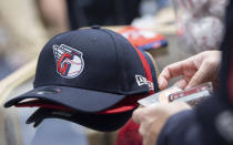 A Cleveland Guardians fan buys new hats at the opening of the team store in Cleveland, Friday, Nov. 19, 2021. It's Day One for the Guardians, who will put caps, jerseys and other merchandise on sale to the public for the first time since dropping the name Indians, the franchise's identity since 1915. (AP Photo/Ken Blaze)