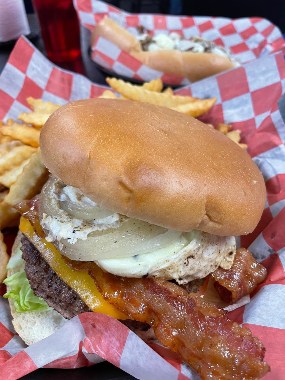 The Heart Attack Burger at Big Orange Philly's in North Knoxville is made up of a half-pound beef patty topped with bacon, smoked cheddar cheese, a fried egg, grilled onions, an onion ring, barbecue sauce, lettuce and tomato.