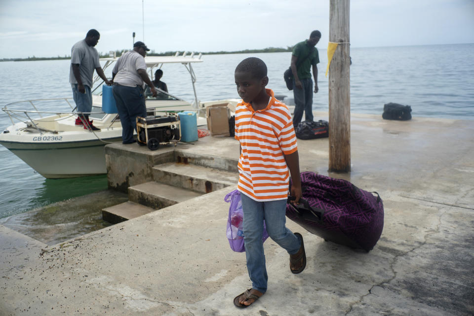 A child evacuated from a nearby Cay due to the danger of floods drags his suitcase when he arrives on a ship at the port before the arrival of Hurricane Dorian in Sweeting's Cay, Grand Bahama, Bahamas, Saturday Aug. 31, 2019. Dorian bore down on the Bahamas as a fierce Category 4 storm Saturday, with new projections showing it curving upward enough to potentially spare Florida a direct hit but still threatening parts of the Southeast U.S. with powerful winds and rising ocean water that causes what can be deadly flooding. (AP Photo/Ramon Espinosa)