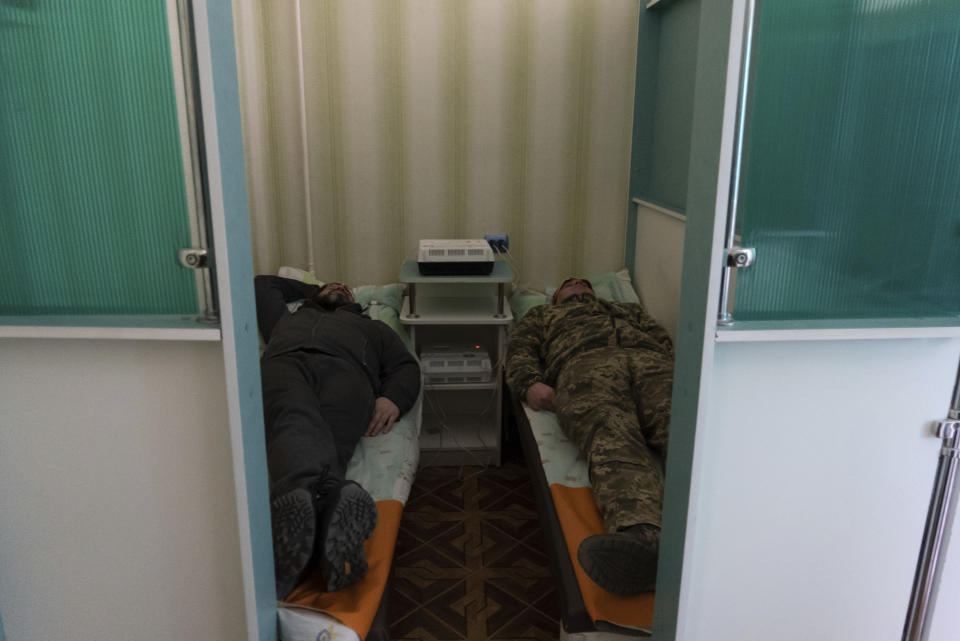 Ukrainian soldiers lay down during a electrosleep therapy session at a rehabilitation center in Kharkiv region, Ukraine, Friday, Dec. 30, 2022. The relentless 10-month war has prompted a local commander to transform an old soviet-era sanatorium into a recovery center for servicemen to treat both mental and physical ailments. (AP Photo/Vasilisa Stepanenko)