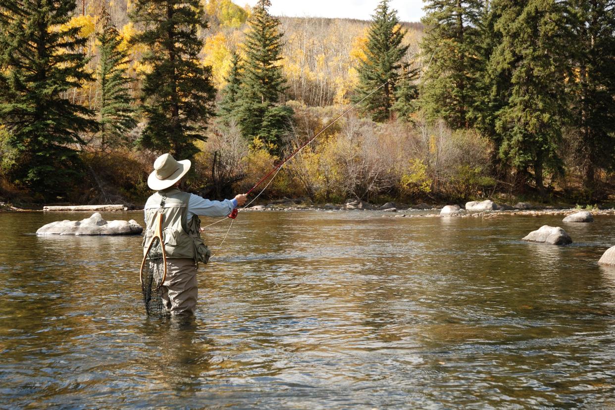 man fly fishing in the water of a river in Colorado