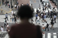 People wearing a protective face mask to help curb the spread of the coronavirus walk at Shibuya pedestrian crossing Thursday, July 9, 2020, in Tokyo. The Japanese capital has confirmed more than 220 new coronavirus infections, exceeding its previous record.(AP Photo/Eugene Hoshiko)