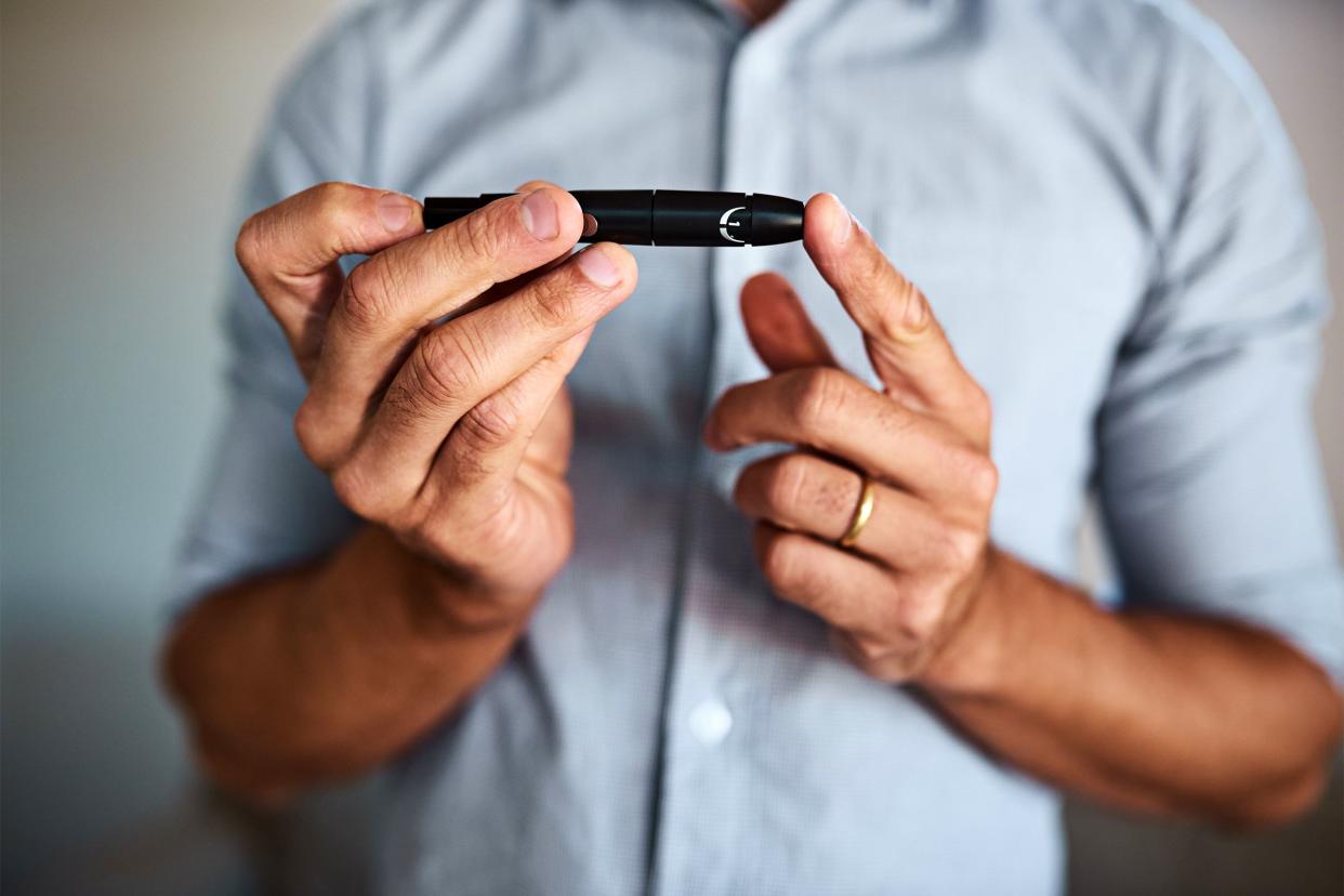 Man pricking his finger to test his insulin levels