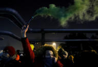 A demonstrator holds a smoke flare during a protest against a proposed new labor law, billed as the "slave law", outside the headquarters of the Hungarian state television in Budapest, Hungary, December 17, 2018. REUTERS/Bernadett Szabo